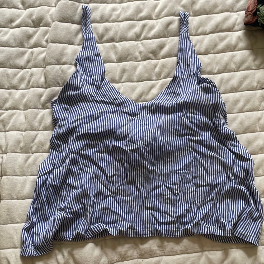 A blue and white striped shirt, bow on back, double shoulder straps